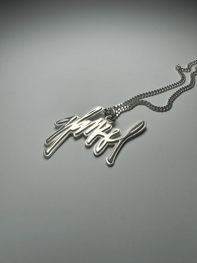 ein Kettenanhänger mit einem individuellen Schriftzug, der das Ergebnis einer persönlichen Sonderanfertigungs-Beratung in Hamburg ist.