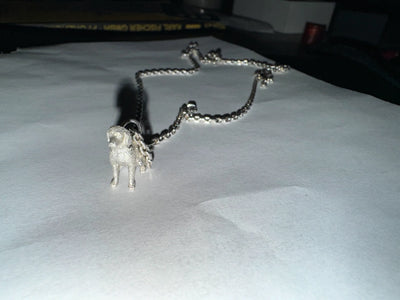 Ein individuell gefertigter Kettenanhänger in Form eines Hundes, der die persönliche expertise der Schmuck-Sonderanfertigungen von Zweisilber belegt.