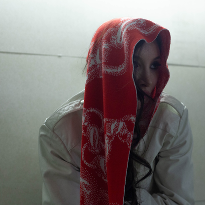 Ein hochwertiger Schal aus weicher Merinowolle, verziert mit dem charakteristischen Zweisilber Kettendesign in rot.