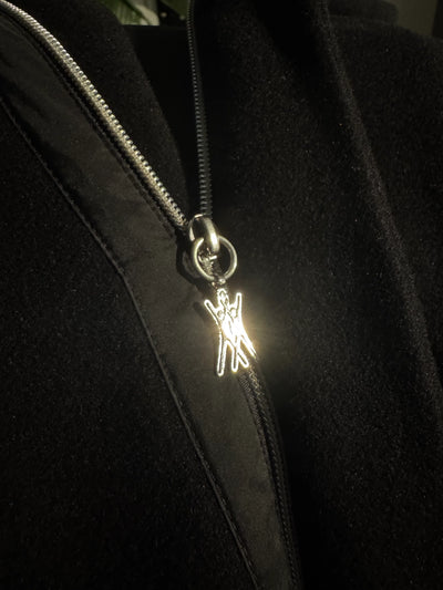 ein Zipper-Anhänger aus recyceltem Silber, der in Handarbeit in Kooperation mit der Schleuse gefertigt wurde und den lokalen Bezug zu Hamburg-Schanze unterstreicht.